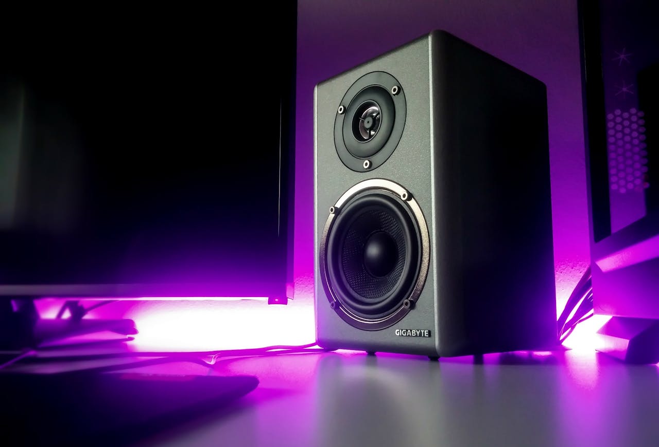 About High-quality speaker setup with vibrant purple lighting in a modern studio setting.
